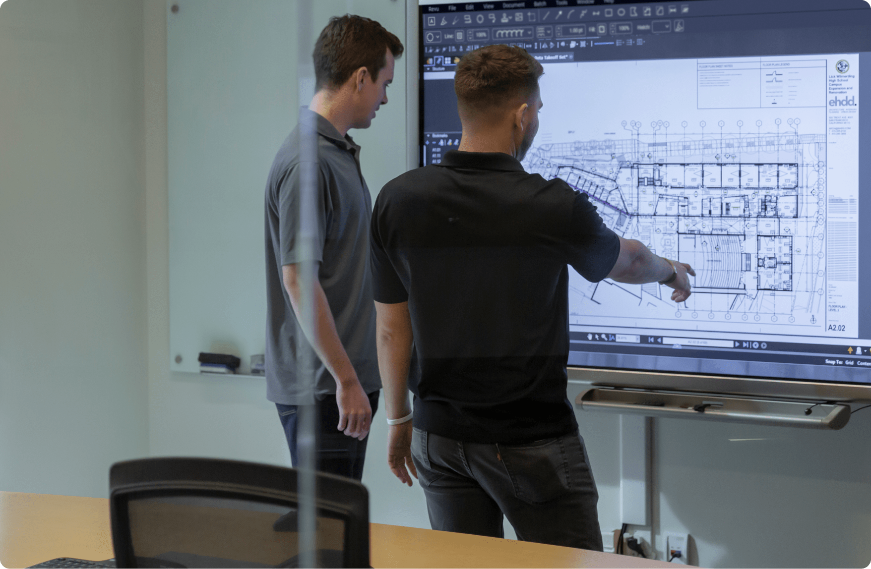 Two men pointing at a TV screen