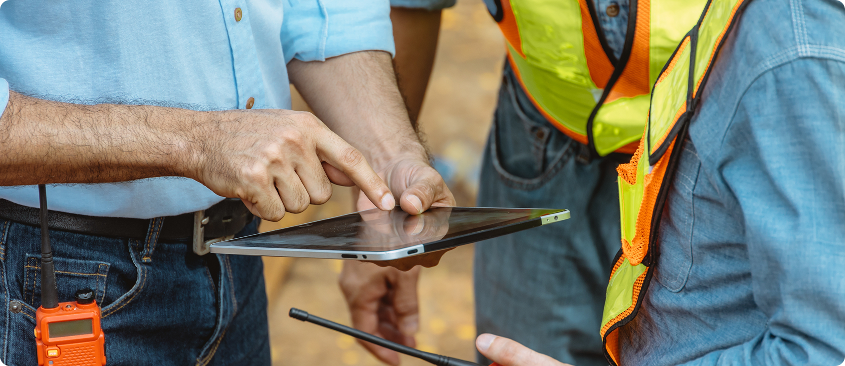  Construction workers huddle around tablet 