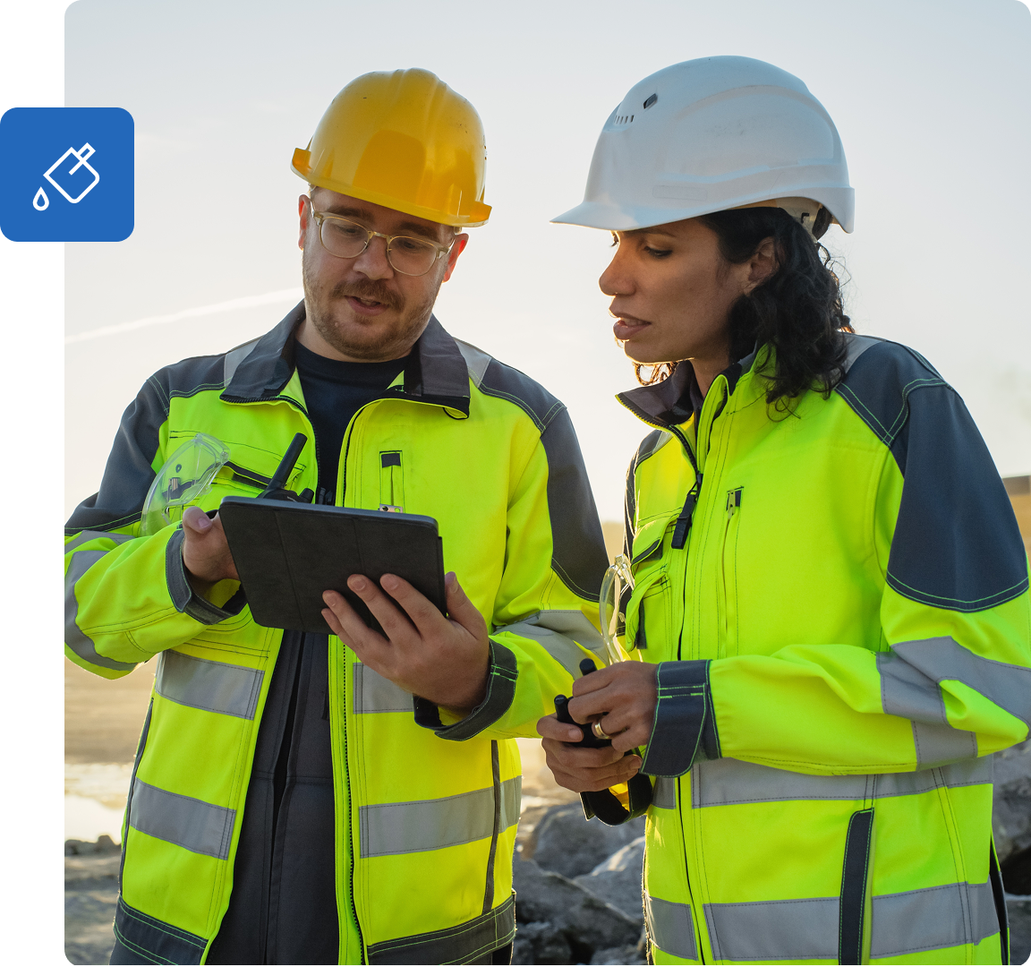 Two construction workers look at tablet together