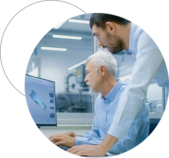 Two office workers look at computer monitor together