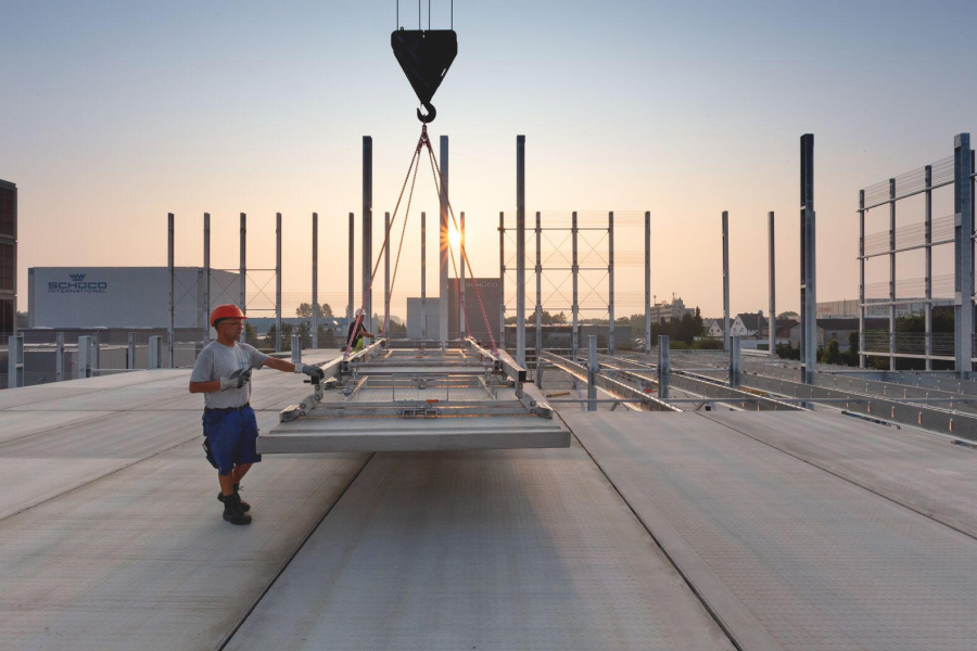 Goldbeck construction crew laying down panel using a crane