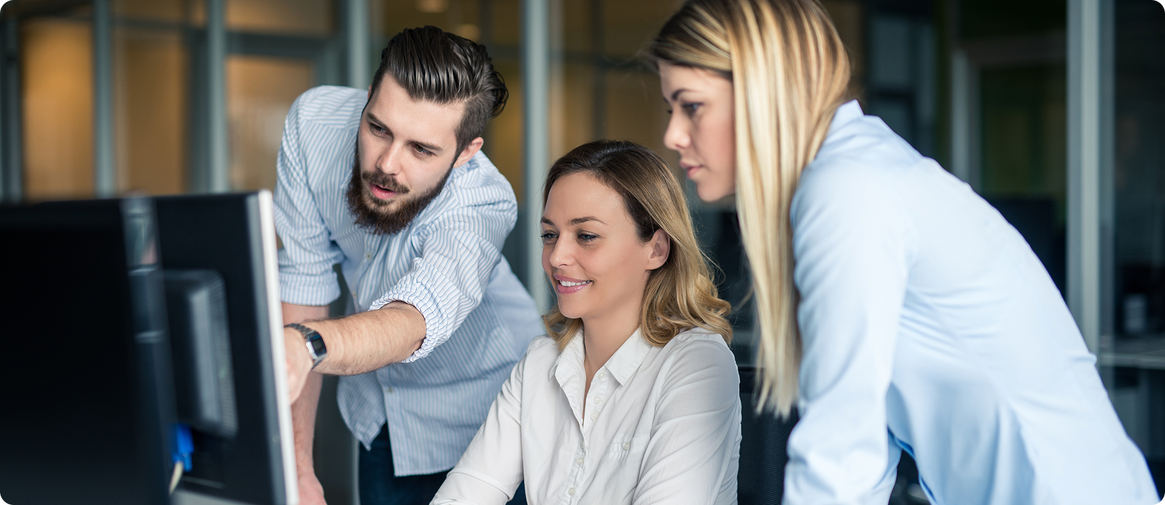  Three office worker looking at monitor together 