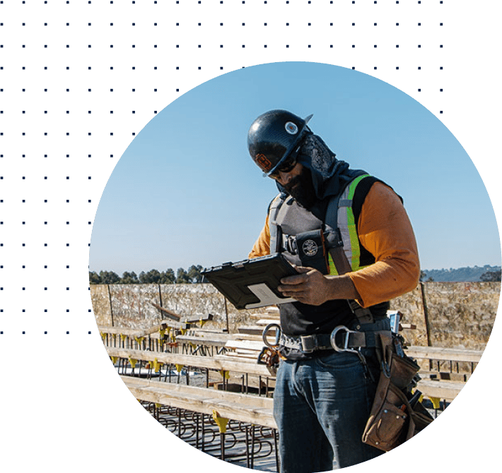 obrero de la construcción en la obra con EPI trabajando en una tableta