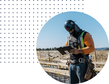 construction worker on site in PPE working on tablet