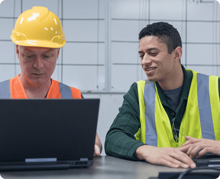 Construction workers looking at a laptop