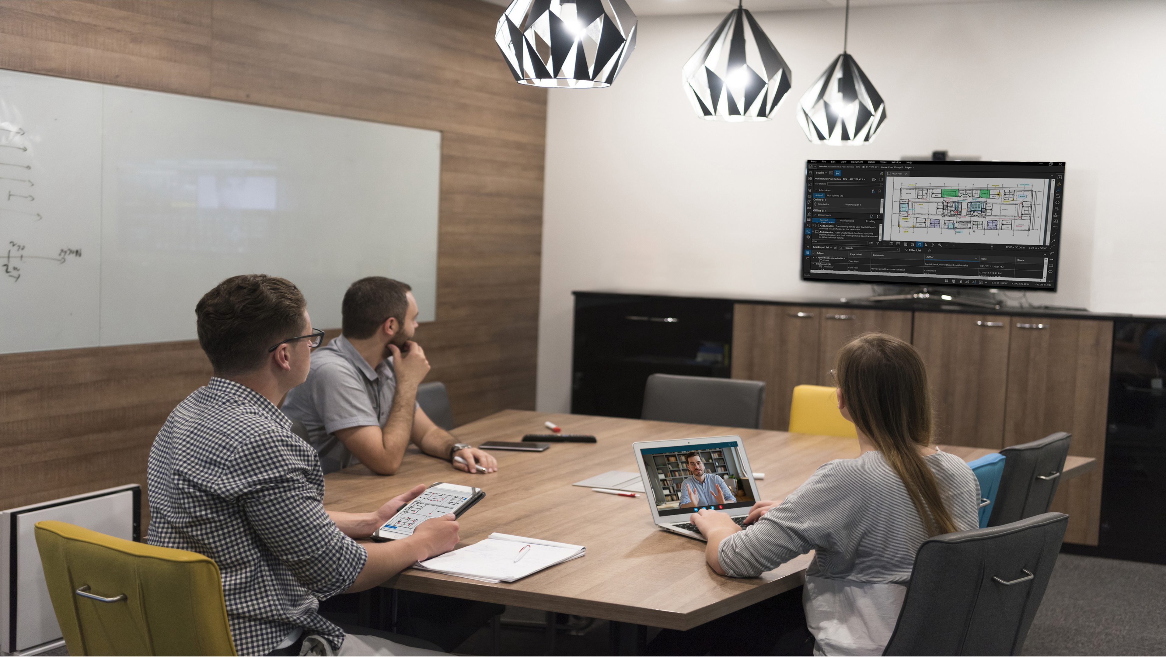 Four coworkers gathered in conference room with Revu on the TV