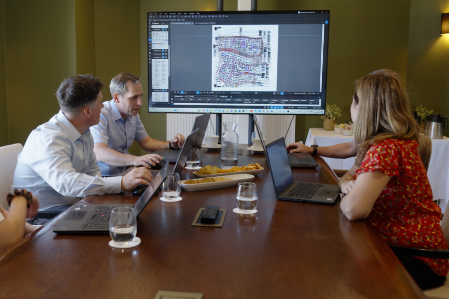 A group of Vinic employees look at Bluebeam on TV in a conference room