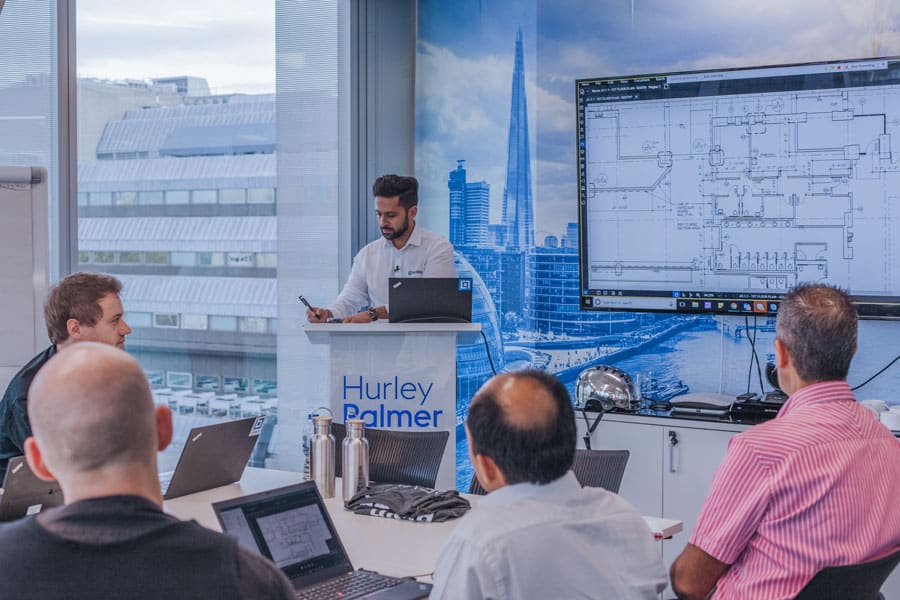 people meeting in office looking at digital construction drawings