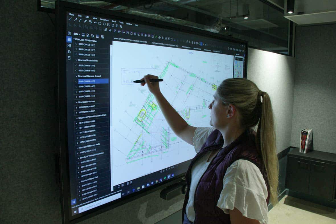 woman working on large digital blueprint