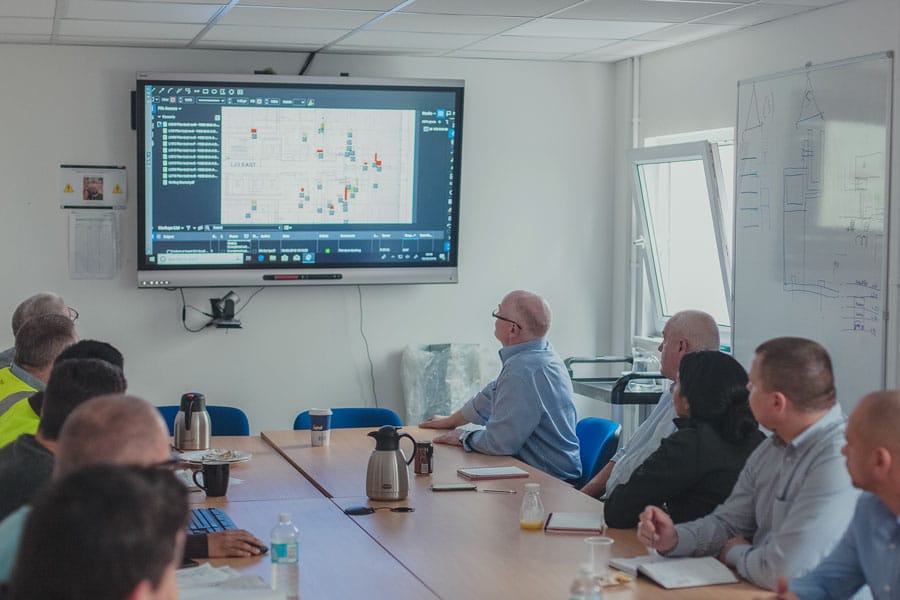 people in a meeting room looking at digital construction software