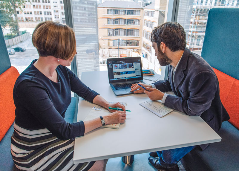 two people working on laptop in office