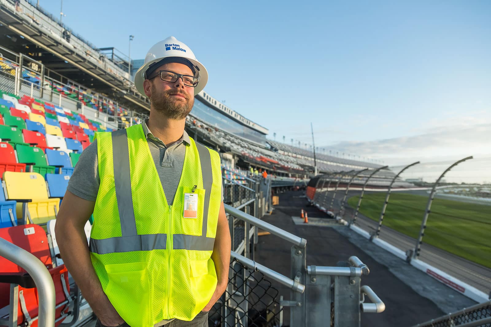 man in construction vest standing in auto speedway