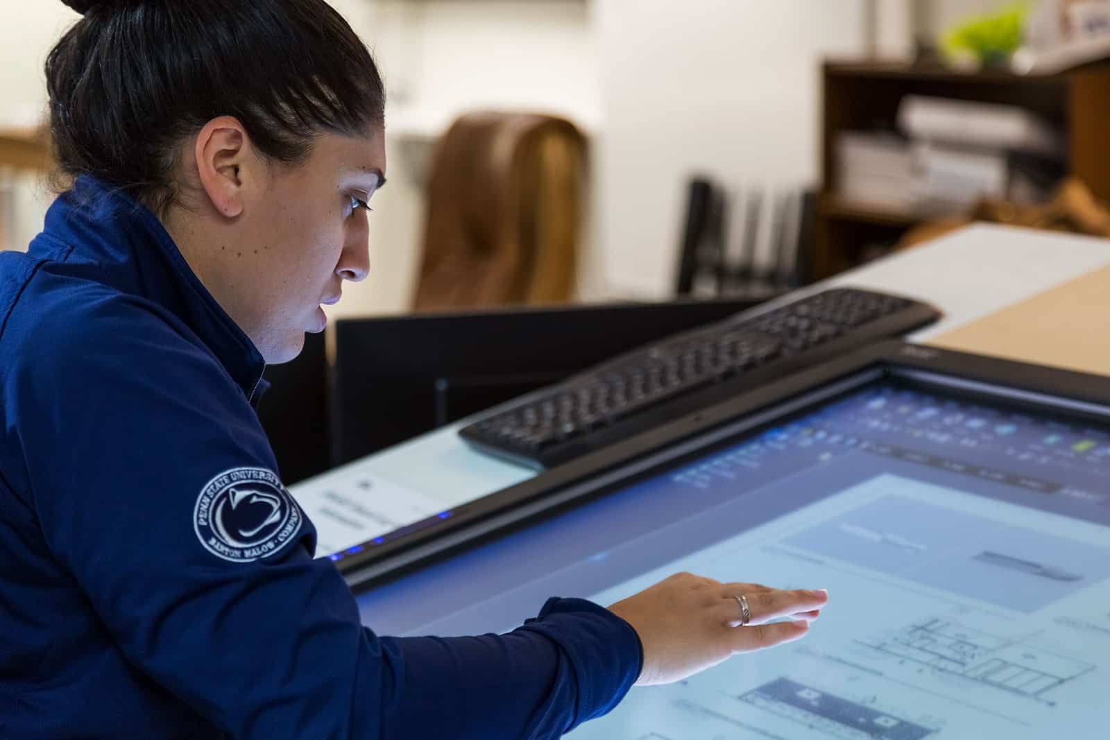 woman working on large screen with construction files