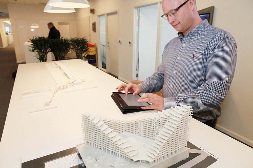 man using tablet near architectural model