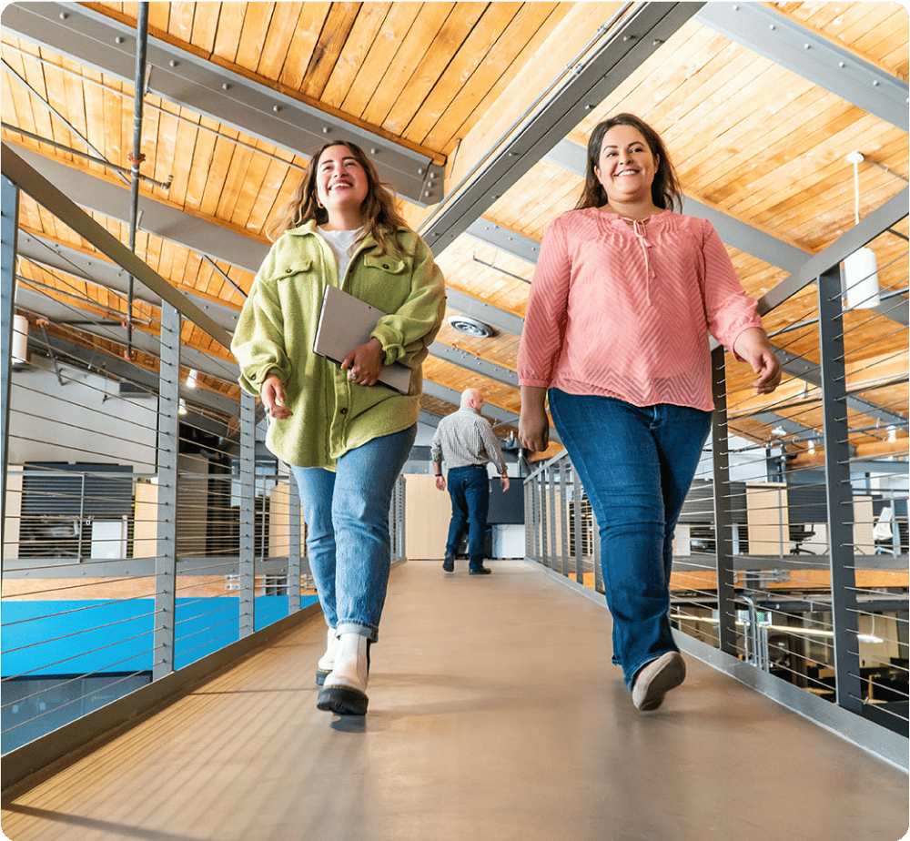two Women walking and smiling in Bluebeam office