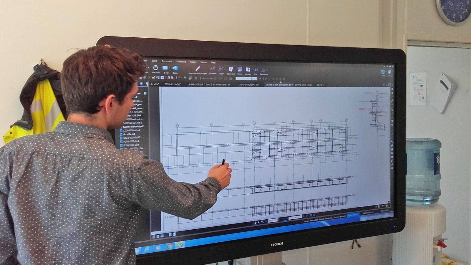 Man pointing at construction drawing on big screen