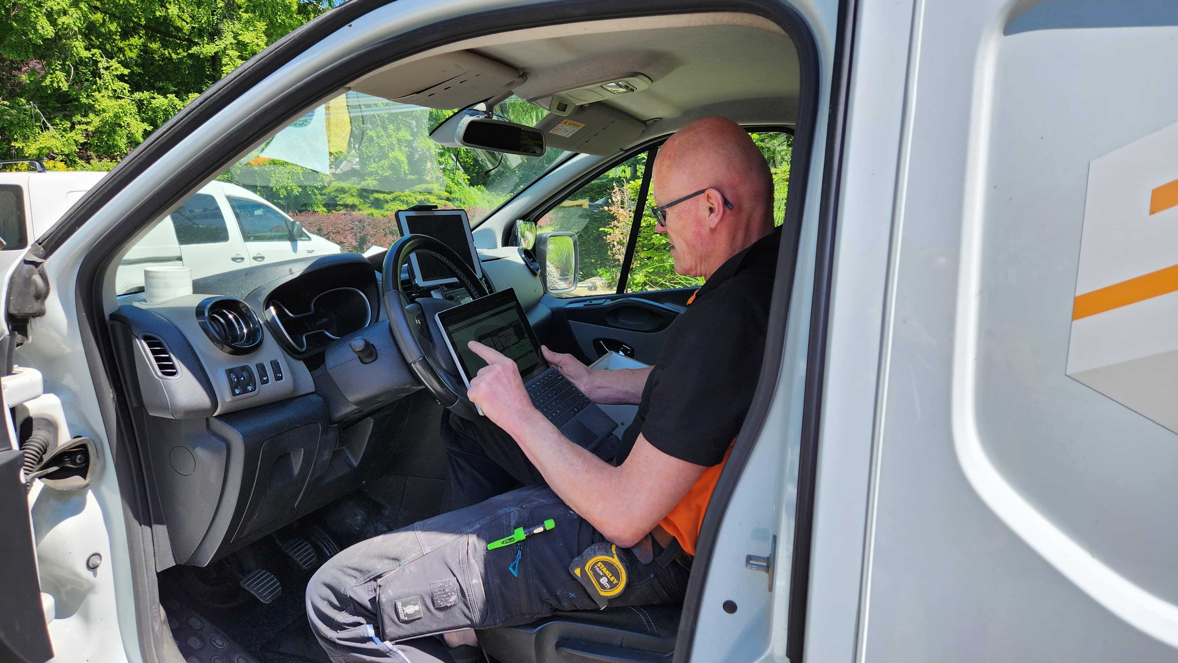 An SMG employee looks at Revu on a laptop in a van