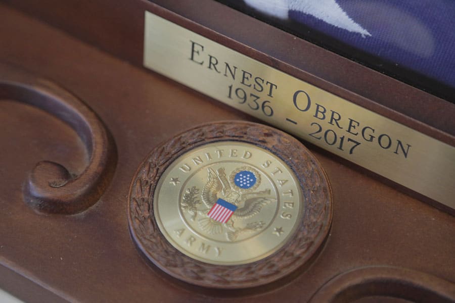 A close-up of a wooden American flag display case reading