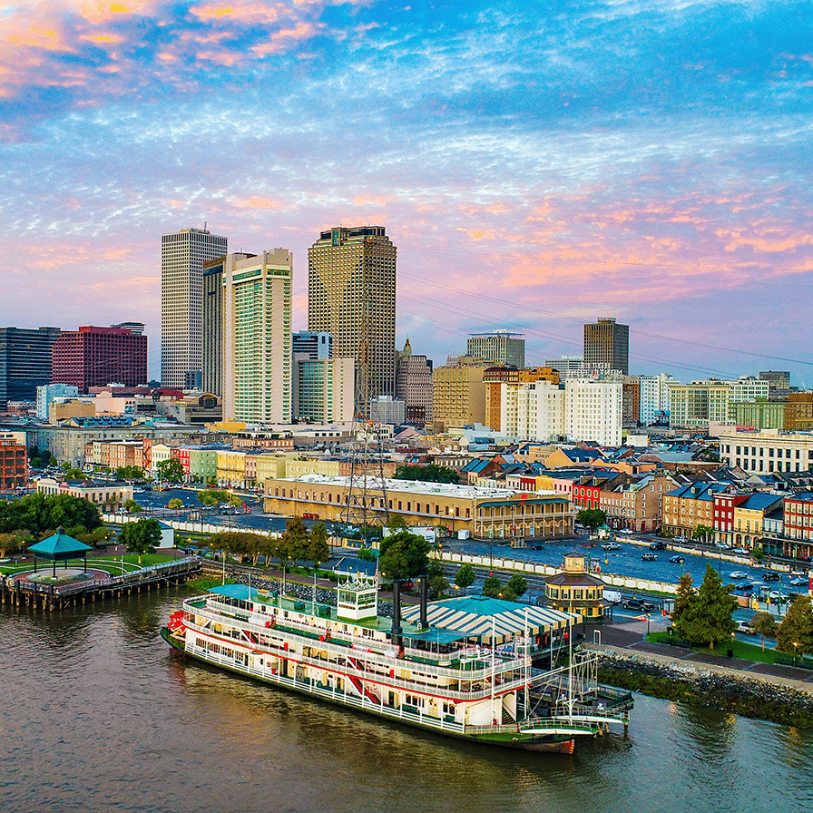 A picture of the New Orleans skyline, with a river and boat in the foreground