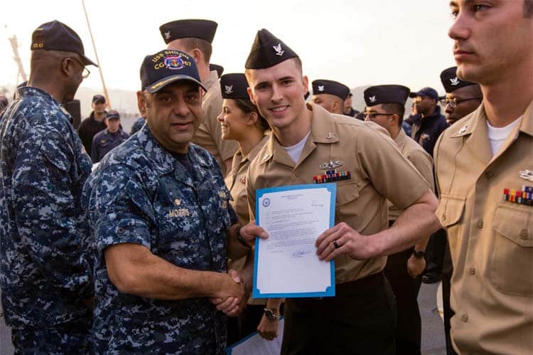 Brandon Cullum in naval uniform holding a certificate