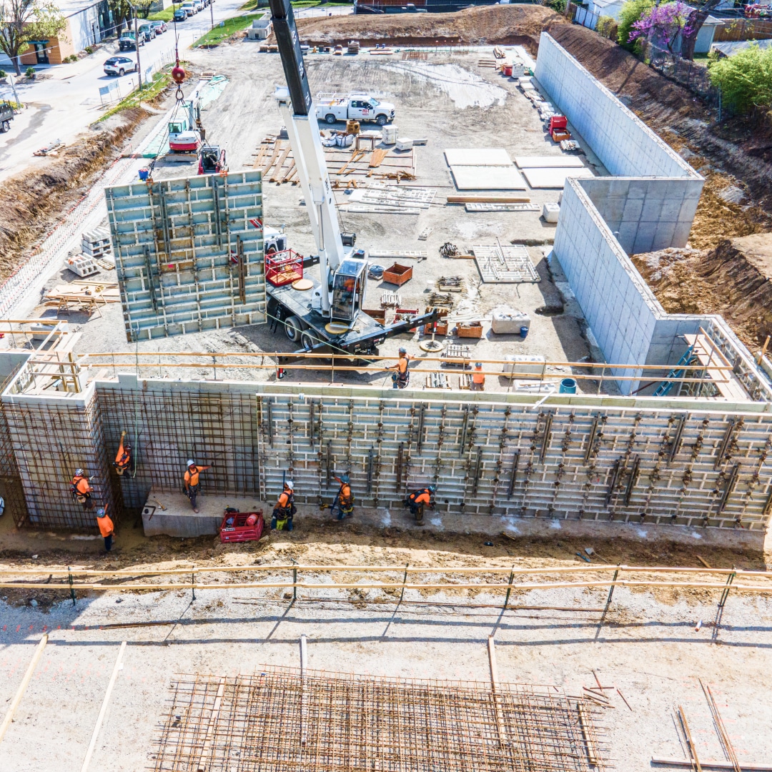 Aerial view of a jobsite with a wall being built.