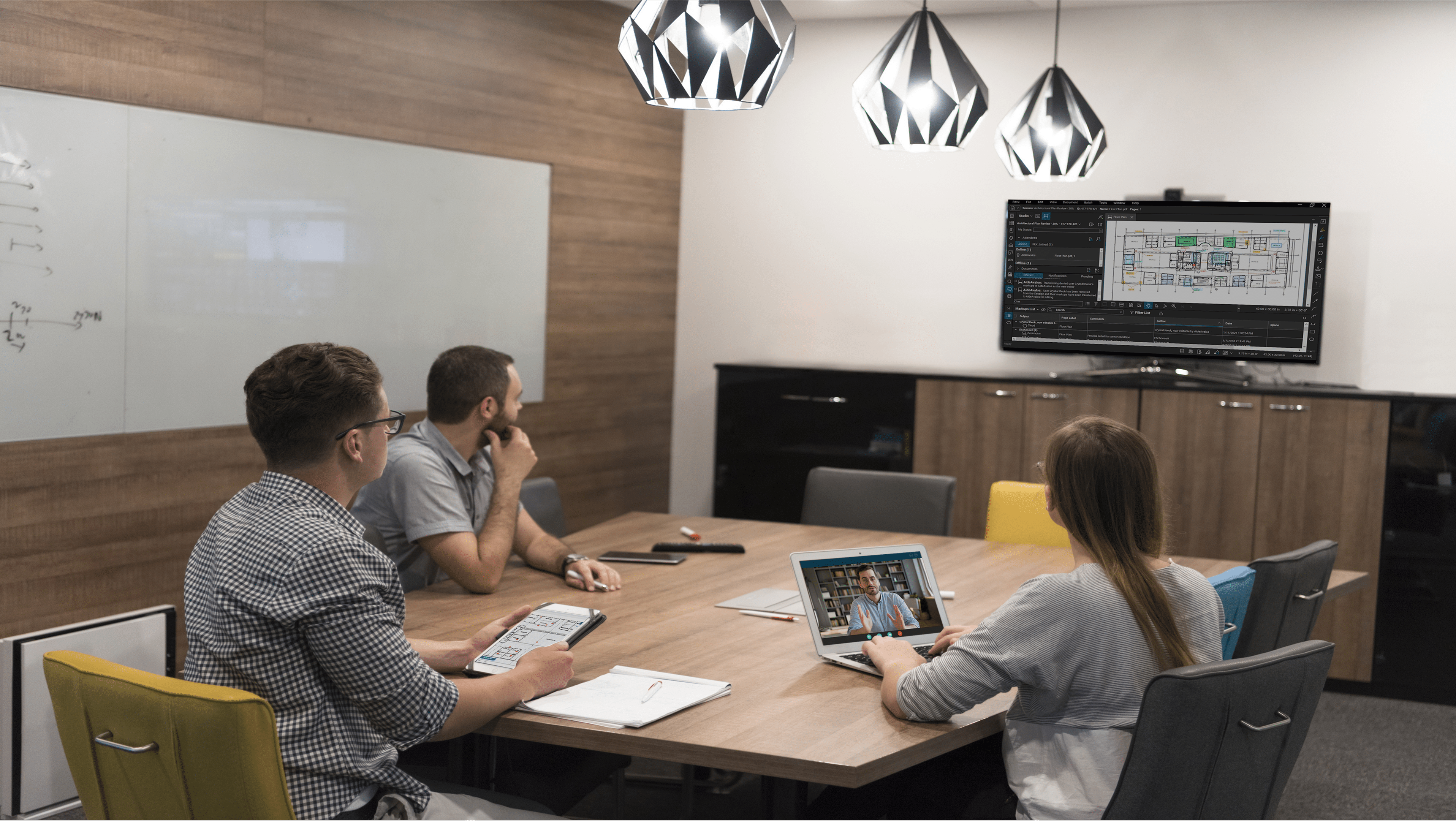 Four coworkers gathered in conference room with Revu on the TV