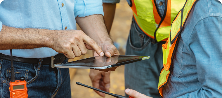 Close up of construction worker tapping on tablet