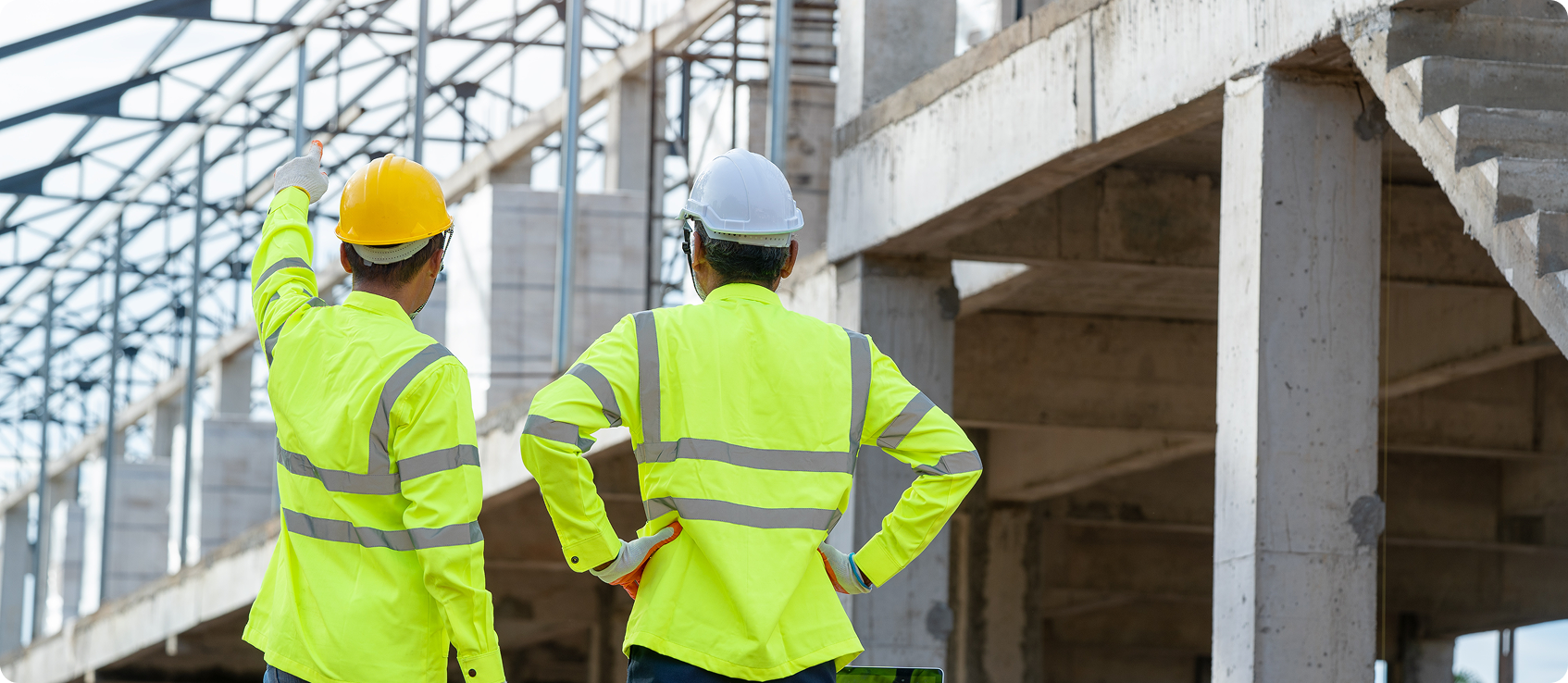  Two construction workers observe a building 