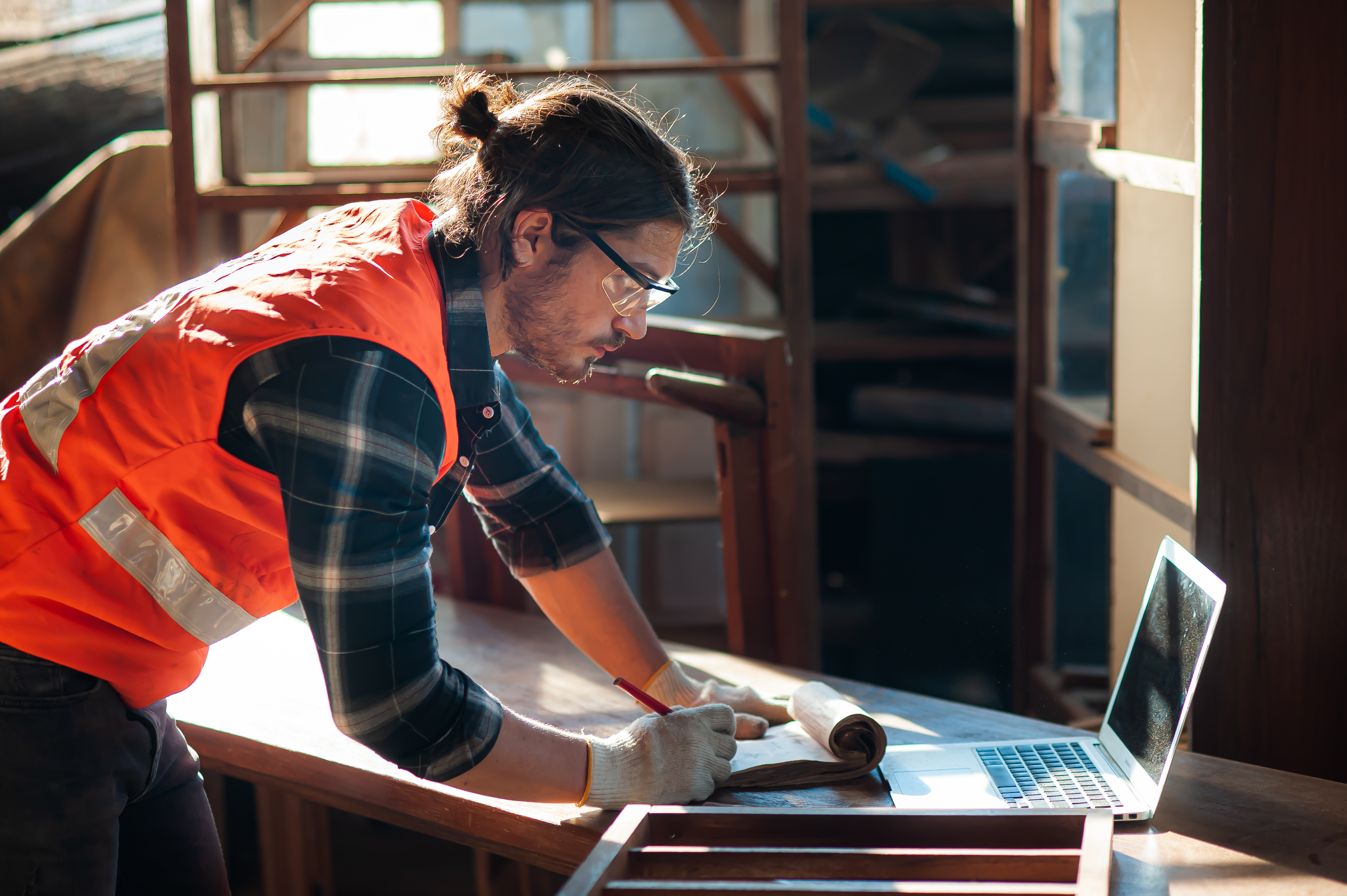 Contractor looks at laptop in workshop