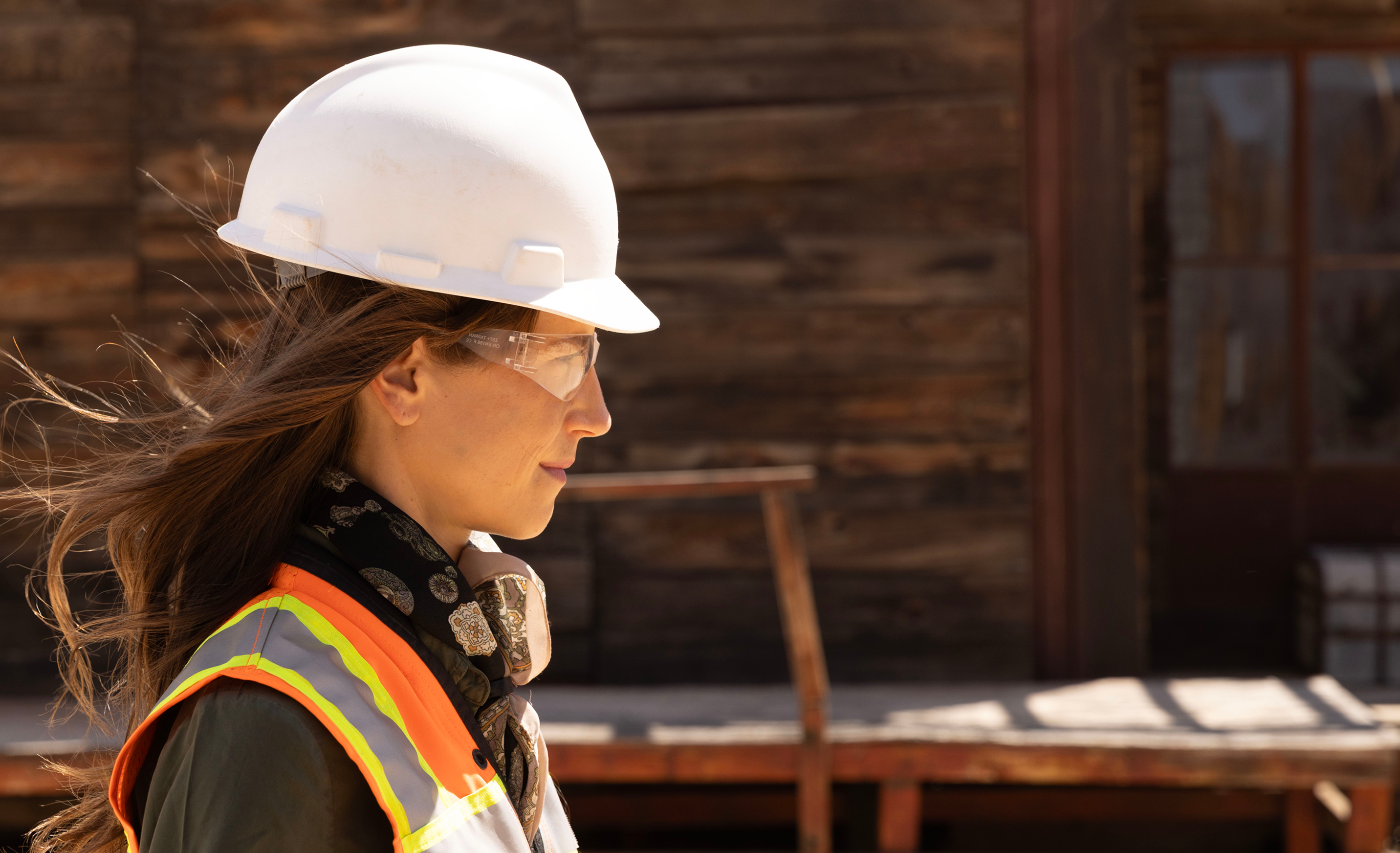 http://Profile%20of%20woman%20construction%20worker%20walking%20through%20old%20west%20town