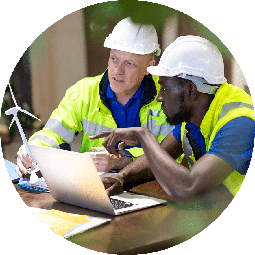 Two construction workers usinga laptop together