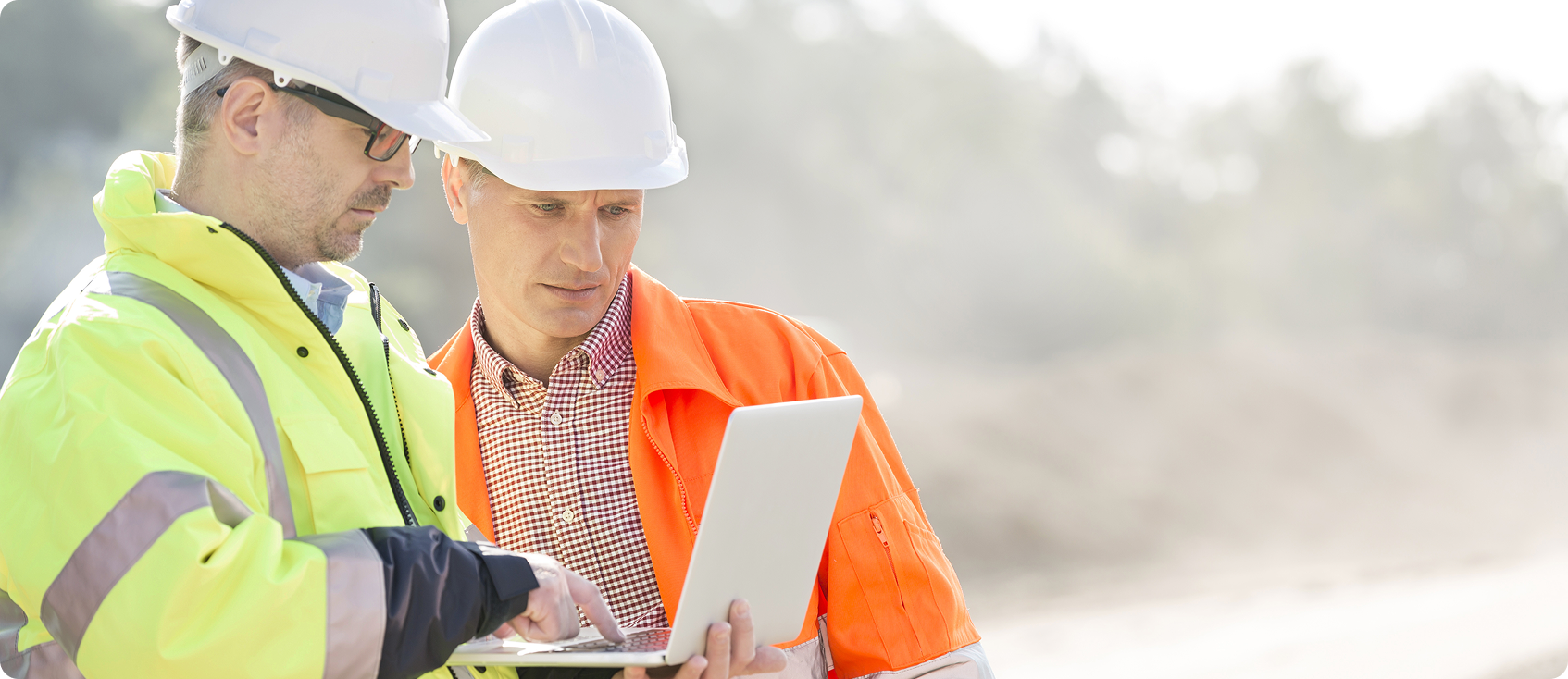  Two construction workers use tablet together in the field 