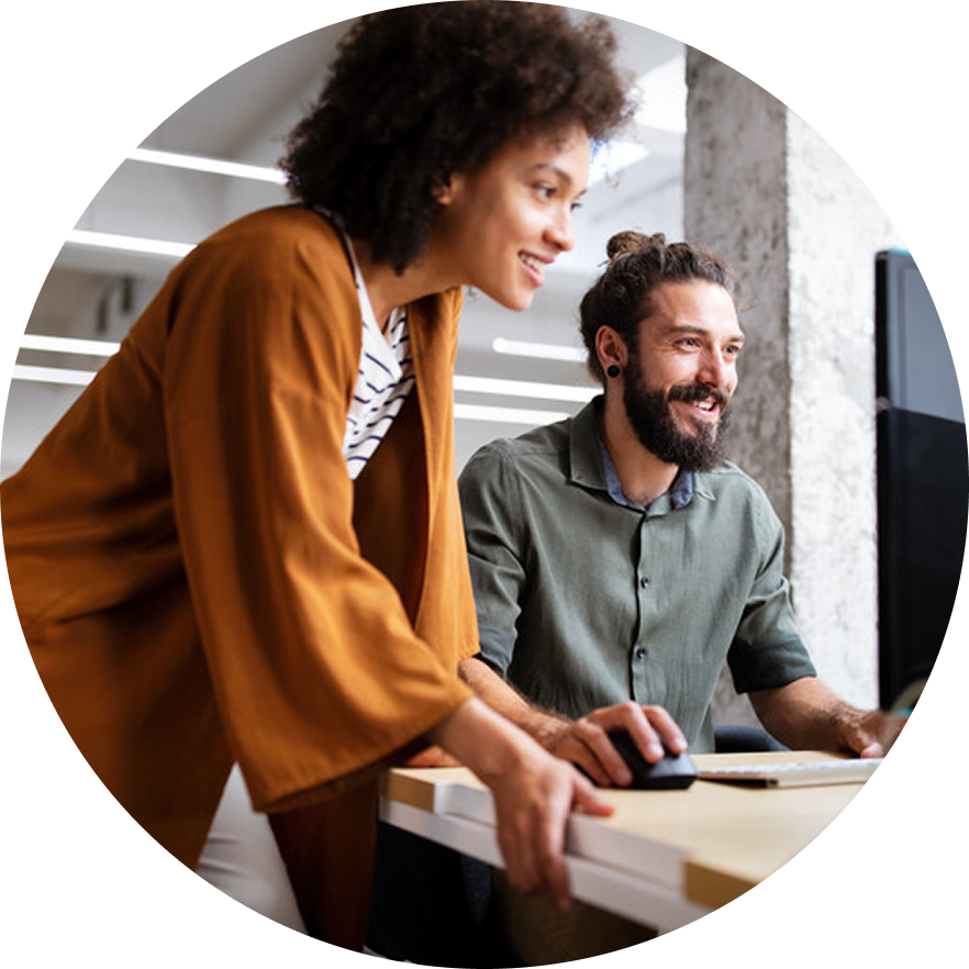 Two coworkers look at monitor