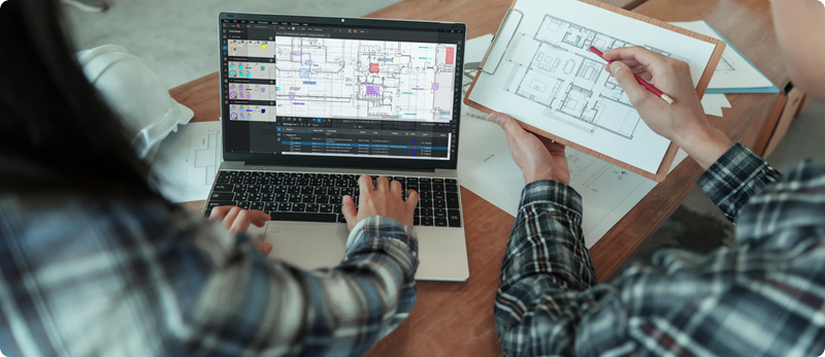 two construction workers looking at Bluebeam Revu on laptop 